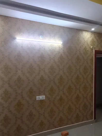 A gold damask wallpaper in an empty room, showing the clean installation.