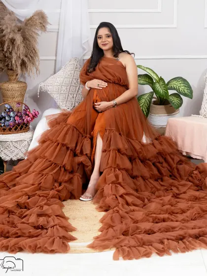 Seated gracefully, this mama-to-be shows off the magnificent train of the brown ruffled gown. A truly stunning and dramatic shot.