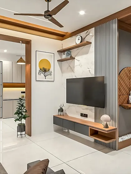 A clean and open living space where the TV unit is integrated with a small pooja corner. The floating console in wood and grey is minimalist, allowing other design elements in the room to stand out.
