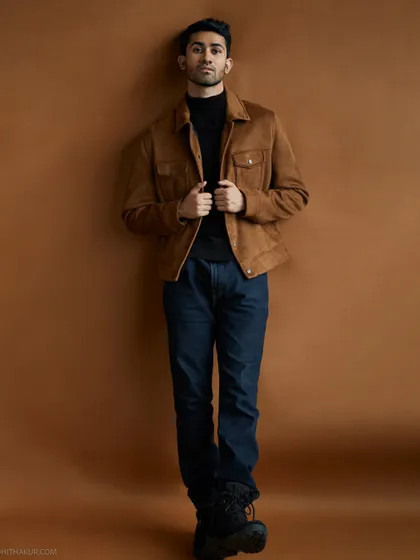 A full-length studio portrait against an earthy brown backdrop. This demonstrates how I work with different looks in one session, from casual to a more styled, layered outfit for a model's portfolio.
