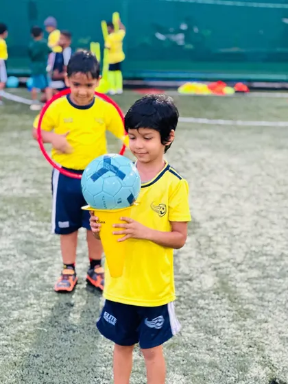 A young player holds a ball on a cone, a simple yet fun activity to improve balance and focus.