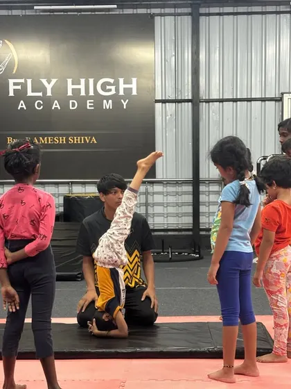 I demonstrate the correct headstand form while the kids' class observes, learning through watching and doing.