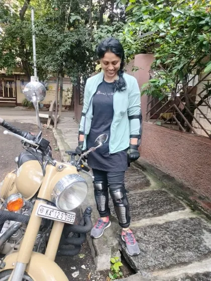 A graduate stands confidently with her bike. She is a statement of strength and a testament to what women can achieve.