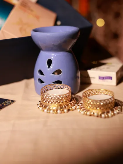 A ceramic diffuser and decorative T-light holders, part of a wellness-themed corporate gift set for Yatra.