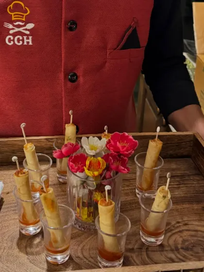 Crispy veg spring rolls served elegantly in shot glasses with a tangy sauce. This is a perfect example of how we blend great taste with creative food presentation.