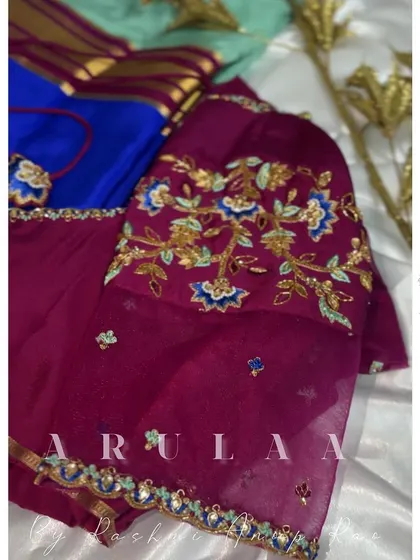 A beautiful blouse with multi-color floral embroidery on sheer sleeves. This is a great way to add color and detail to a simple saree.