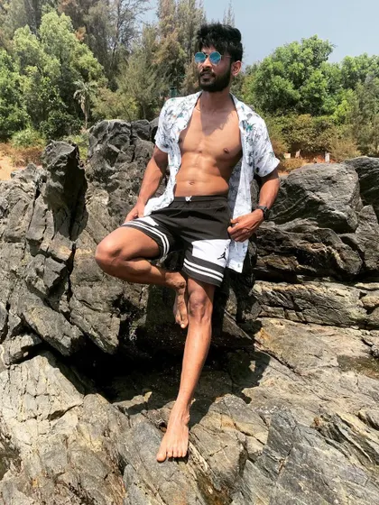 A full-body shot on the rocks, showcasing leg definition and a confident stance.