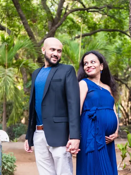 A lovely walking shot of the couple, hand-in-hand. The vibrant blue of her dress contrasts beautifully with the green park, making for a striking and happy photograph.