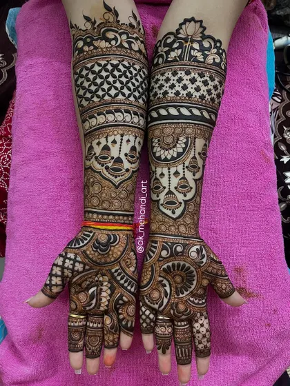 This bridal design incorporates various bands of patterns, including jaal, florals, and hanging bells (jhumkas) for a traditional look.