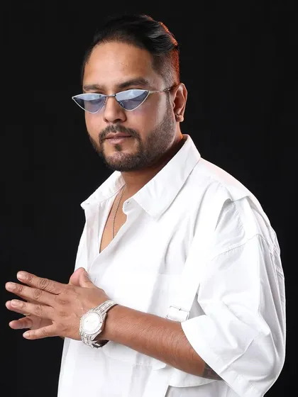 A clean studio shot in a white shirt and cool shades. Sometimes a simple, confident look is all you need.
