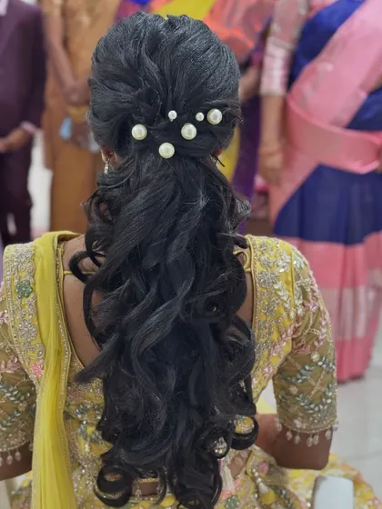 The modern and chic ponytail I created for Abi's reception. The style features soft waves and is adorned with elegant pearl accessories.