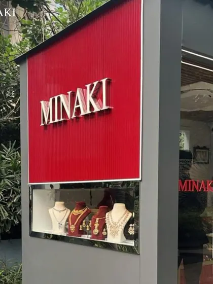 The exterior signage of the Minaki store, with a display window showcasing some of their beautiful necklace sets.