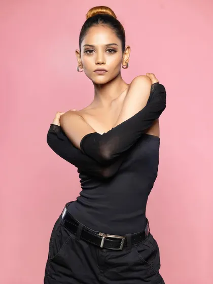 A classic three-quarter portrait against a pink background. The model's pose is strong and confident, making this a great addition to a fashion portfolio.