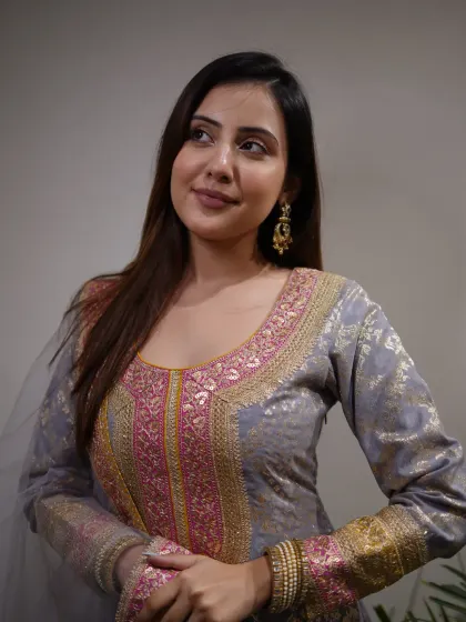 Woven with culture, detailed with beauty. A close-up of this grey suit with intricate pink and gold embroidery.