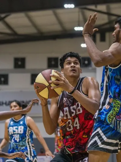 An athlete powers through contact in the paint. We train our players to be strong with the ball and finish through challenges.