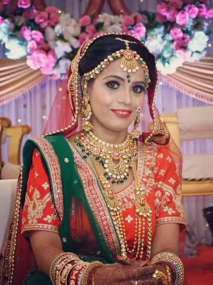 Seated in her bridal glory, this client showcases a full traditional jewellery set that perfectly matches her green and orange saree.