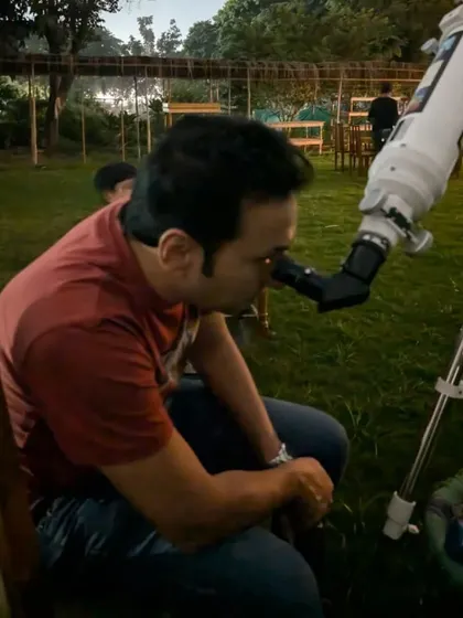 An adult guest takes his turn to look at the stars and planets through our professional telescope.