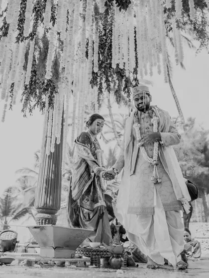 A timeless black and white photograph of the couple during their Maharashtrian wedding pheras. This artistic choice highlights the emotion and solemnity of the sacred ritual.