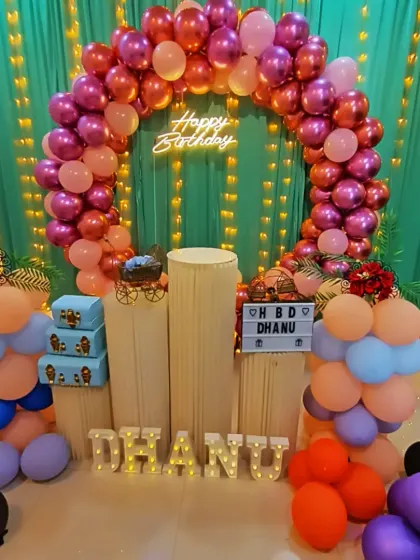 This full-circle balloon arch in bright pinks and oranges shows how I can transform the space with color. I also provide light-up letters to personalize the decor with a name.
