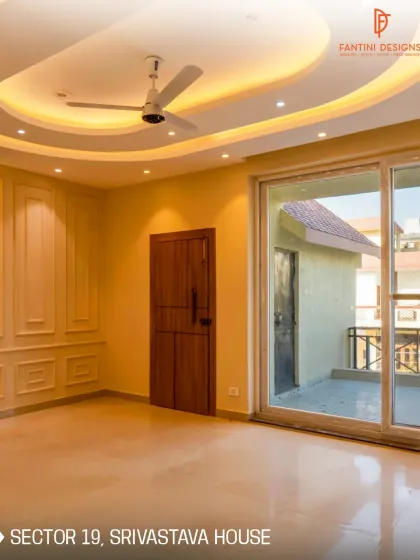 This is the Srivastava House in Sector 19, where classic elegance meets modern design. Notice the details like the wall paneling and the curved false ceiling with cove lighting, which add a touch of sophistication to the room.