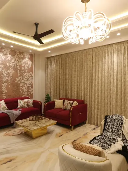 Another perspective of the Harmony Home living area, highlighting the interplay between the bold red and neutral cream sofas, unified by luxurious marble flooring.