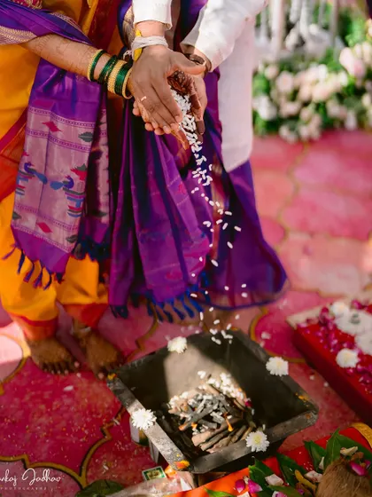 A close-up of the Laja Homa ritual, focusing on the hands and the sacred offerings.