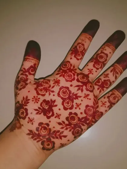 A close-up of a rich, red floral henna stain covering the entire palm. This is the beautiful, mature color you can expect from my organic mehendi a day or two after application.