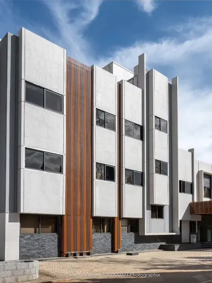 Another view of the Jindal Admin block, showcasing its modern facade with strong vertical lines and a mix of materials. The design maintains a professional and timeless aesthetic consistent with the adjacent school building.