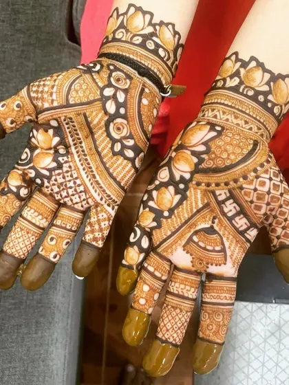 A beautiful Karwa Chauth design with lotus borders and a swastika symbol for good fortune. The use of negative space makes the floral patterns stand out.