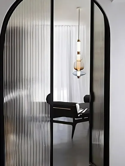 An example of arched doors with ribbed glass panels. This design element adds architectural interest and elegance, perfect for separating spaces without closing them off completely.