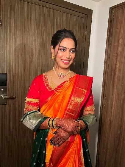 A happy Marathi bride in her vibrant Nauvari saree. The makeup is soft and glowing, designed to last through the wedding rituals while keeping her comfortable.