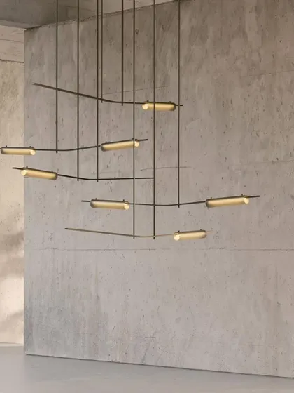 A close-up of the Volant chandelier's equilibrium. Solid brass bars hold the glass elements at precise angles, creating a fixture that feels both enthralling and soothing.