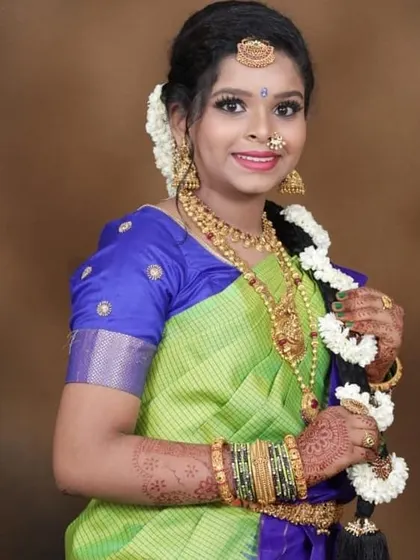 A full portrait from a half-saree event. The hair is styled in a traditional braid with jasmine flowers, completing this classic South Indian celebratory look.