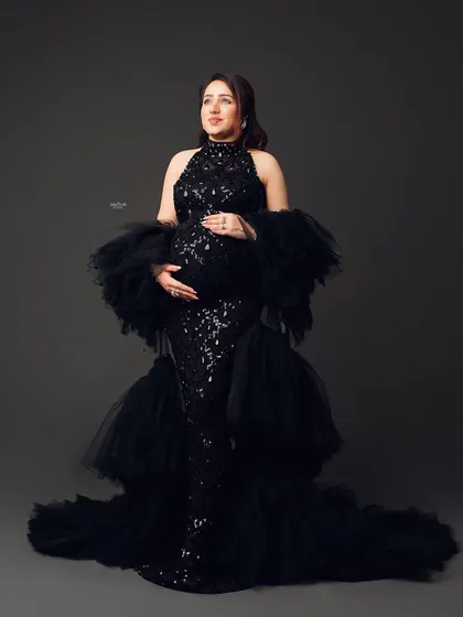 A full-length portrait of a mamma-to-be in a stunning black sequin and tulle gown. This is the epitome of a glam maternity shoot.