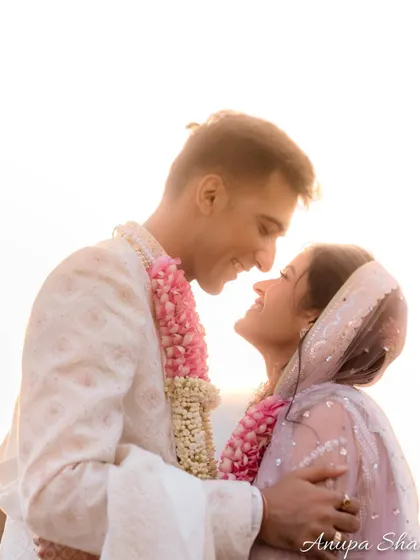 A classic, romantic portrait against the bright sky. The focus is entirely on the couple's loving gaze and the happiness on their faces.