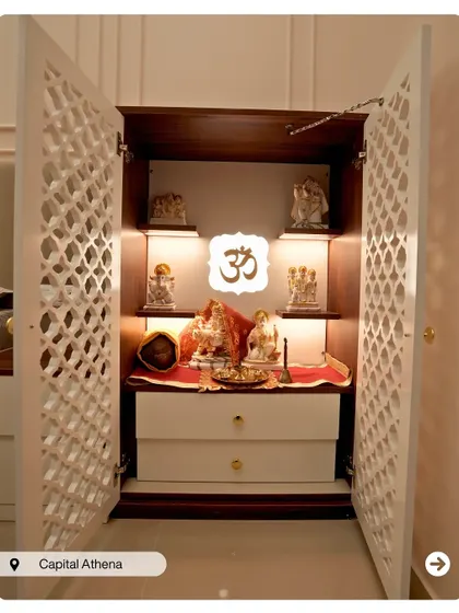A compact and elegant pooja cabinet with latticework doors. The warm interior lighting highlights the idols, creating a beautiful and sacred focal point.
