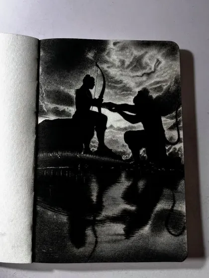 A different angle of the silhouette drawing of Lord Rama and Hanuman. This view highlights the texture of the paper and the deep black of the charcoal used.
