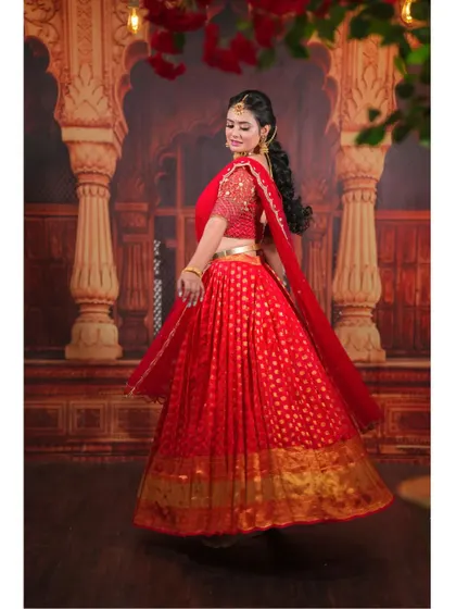 A twirling shot that shows the beautiful flare of the red half-saree skirt.