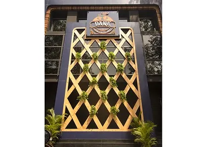 The facade of Dank, a commercial establishment where we integrated a vertical trellis with planters. This design creates a green entrance that is both visually interesting and aligned with a modern, urban aesthetic.