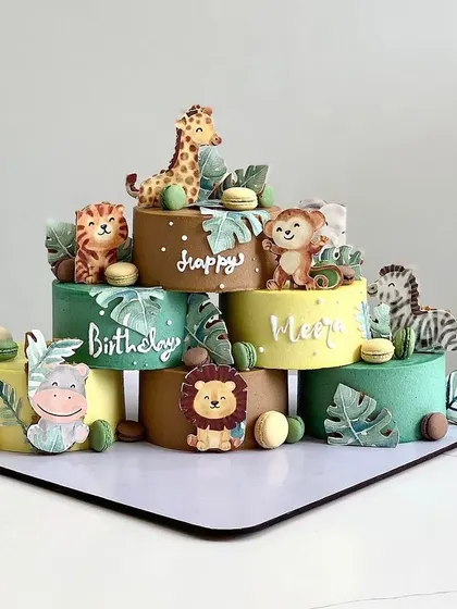 A unique jungle-themed setup using multiple mini cakes to create a larger scene. This is a creative way to cater to different flavors or create a stunning dessert table centerpiece.