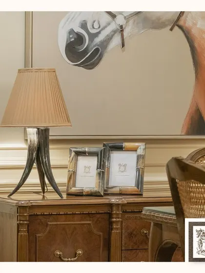 This unique table lamp features a base made from horns, bringing a touch of rustic, equestrian-inspired style to a classic wooden desk. It's a perfect piece for creating a sophisticated and warm ambiance.