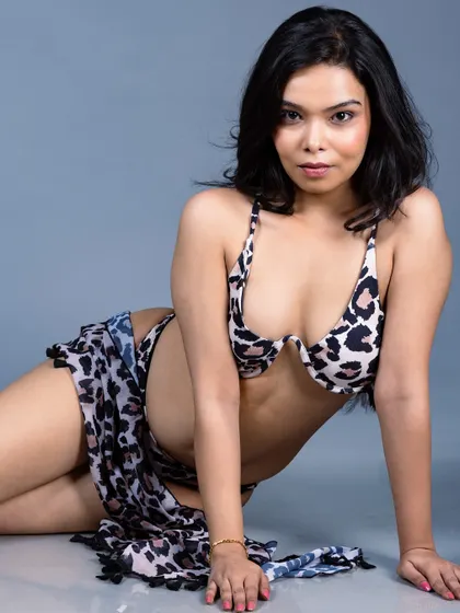 A relaxed, reclining pose of a model in an animal print bikini.