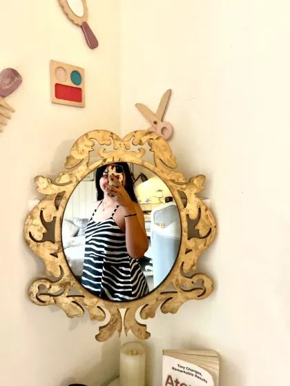 Our vintage mirrors are perfect for capturing your look. A guest takes a selfie, reflecting the cozy and stylish ambiance of the cafe corner.