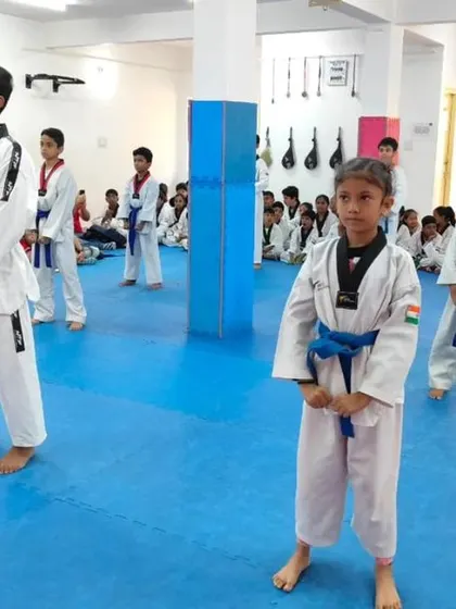 A group of blue and green belts in their ready stance.