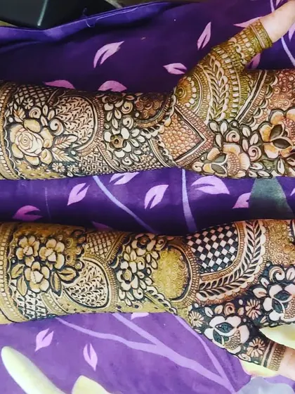 This design combines bold floral elements with delicate, lace-like patterns. The contrast creates a beautiful and eye-catching bridal mehendi look.