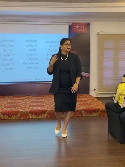 Explaining the nuances of professional presence to a corporate audience. The slide behind me lists attributes of a strong professional image, a core topic in my leadership development programs.