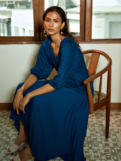 A full-length seated portrait from the same series. The composition is graceful and shows the flow of the dress, perfect for a brand lookbook.