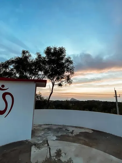 As the sun sets over the hills, a profound stillness settles over the ashram. The Om symbol on our wall is a constant reminder of the universal sound that connects us all. This is the peace you will find here, a quiet space to reconnect with your soul.