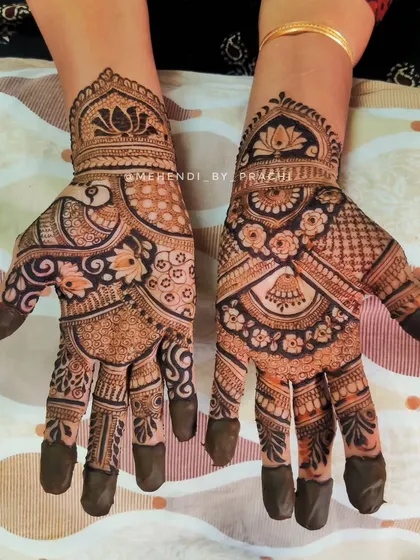 A beautiful example of intricate Indian henna art. This design combines floral elements, a peacock, and traditional bell (jhumki) motifs for a full and festive look.