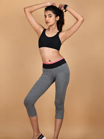 A clean studio shot for an activewear or fitness apparel brand. The simple background and clear lighting ensure the focus remains on the fit and style of the clothing.